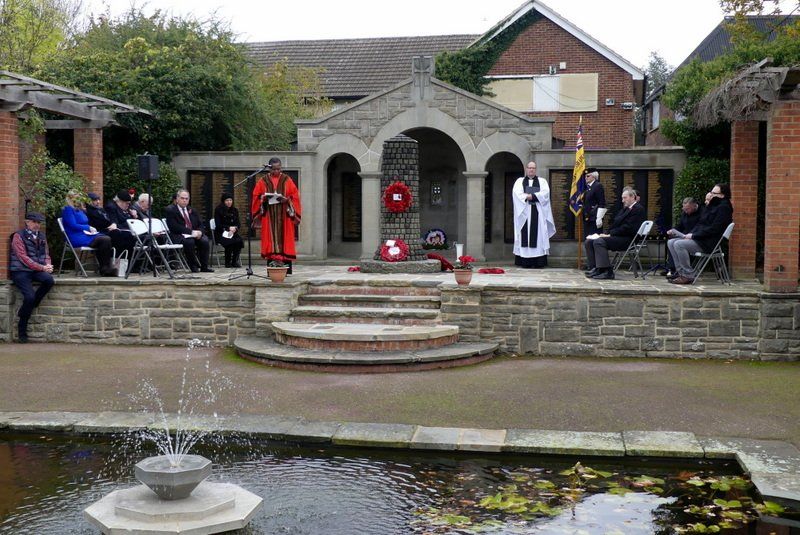 A group of people are sitting in chairs in front of a fountain.