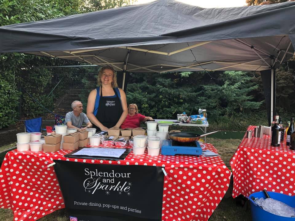 A woman is standing in front of a table under a tent.