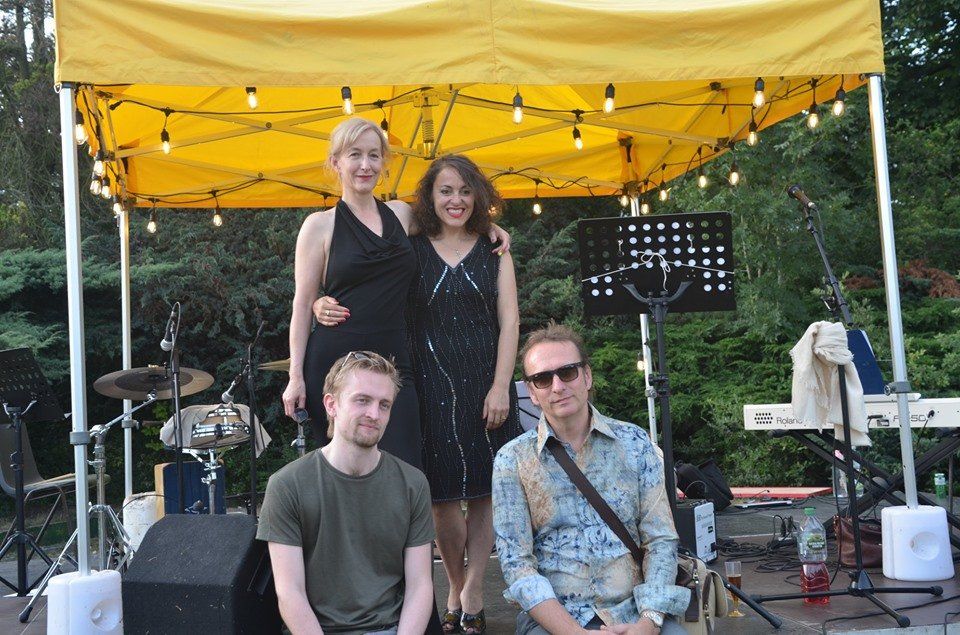 A group of people are posing for a picture under a yellow tent.