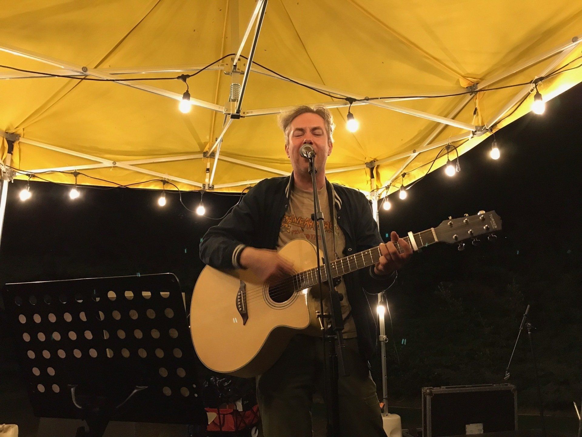 A man is playing a guitar and singing into a microphone.