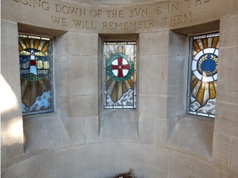 A stone wall with stained glass windows and a sign that says 