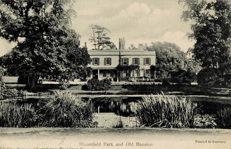 A black and white photo of a large house in a park