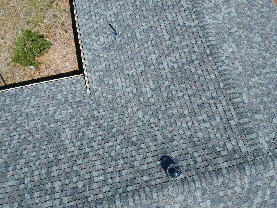 Aerial view of a paved walkway beside a dirt planter, with a lone shoe on the ground.