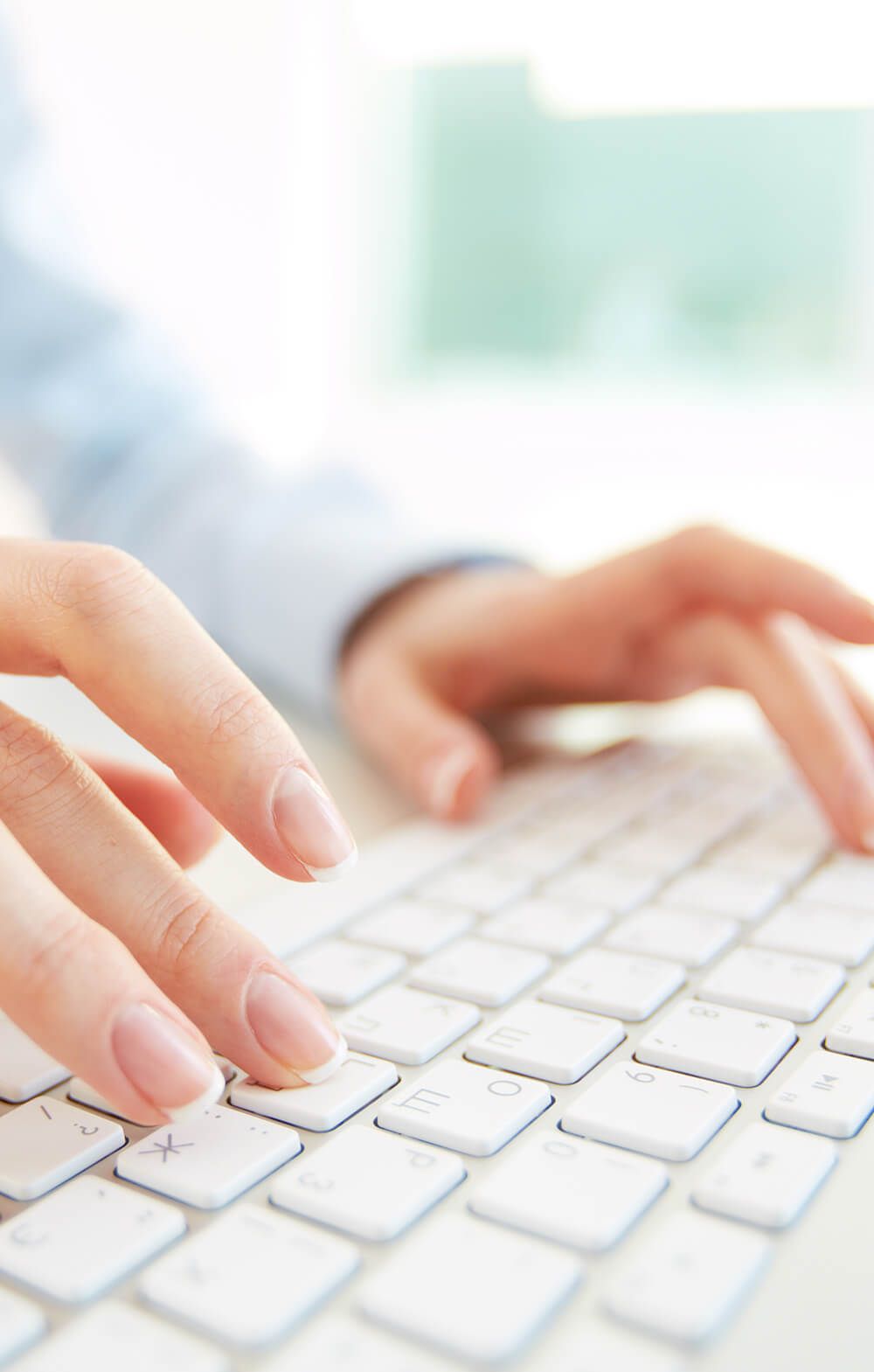 woman typing on a white keyboard