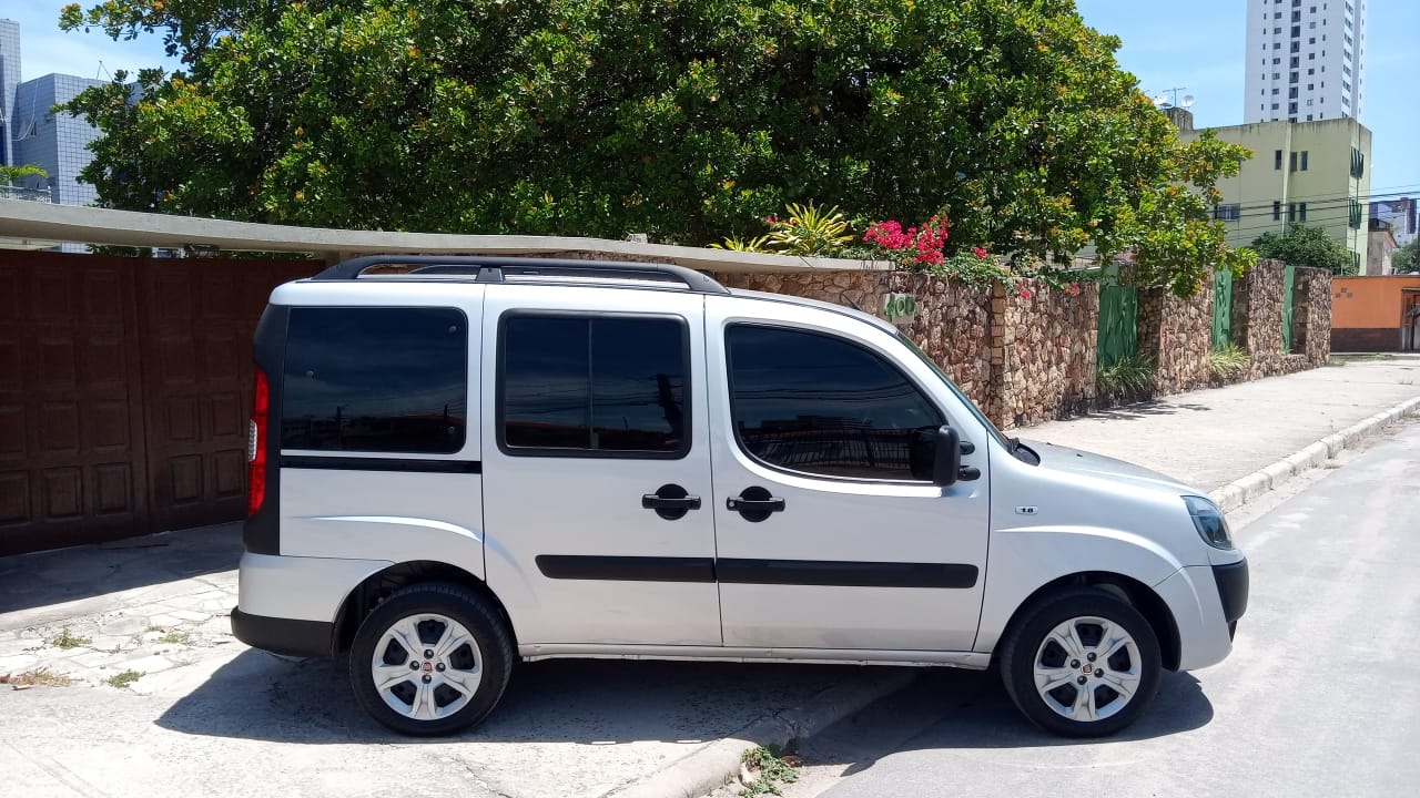 Uma van branca está estacionada na beira da estrada.