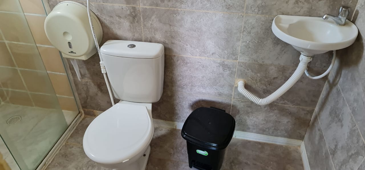 Um banheiro com vaso sanitário, pia e chuveiro.