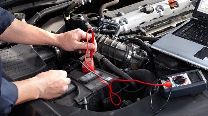 elettrauto in officina durante un controllo dell'auto