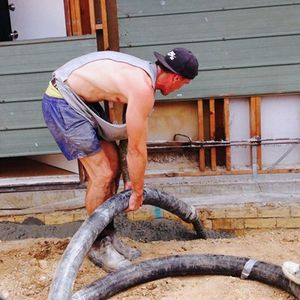 Driveways and Pathways man pumping concrete to make path