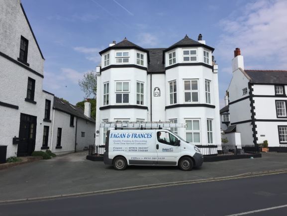 A house painted white with van outside