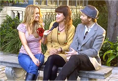 A man and two women are sitting on a bench talking to each other