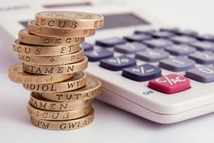 stack of pound coins and a calculator