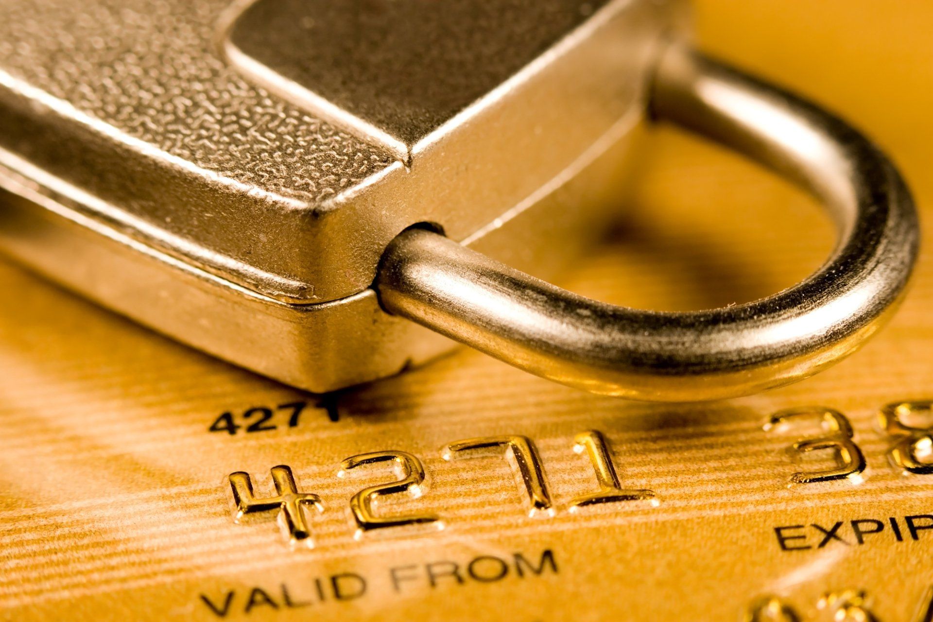 Credit card partially covered by a padlock, representing financial security and protection.