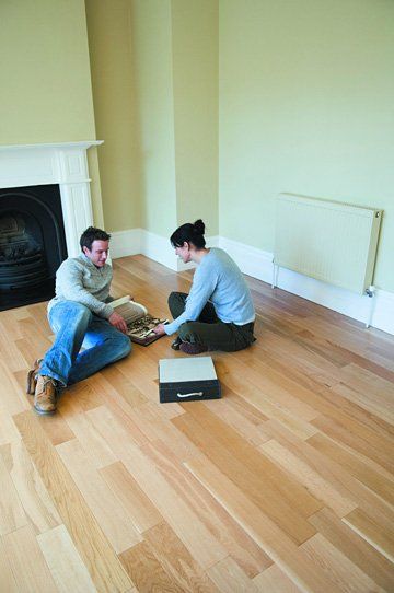Laminate Flooring - Mike Baddeley Ltd - York, Yorkshire - couple sitting on laminate flooring Laminate Flooring - Mike Baddeley Ltd - York, Yorkshire - couple sitting on laminate flooring