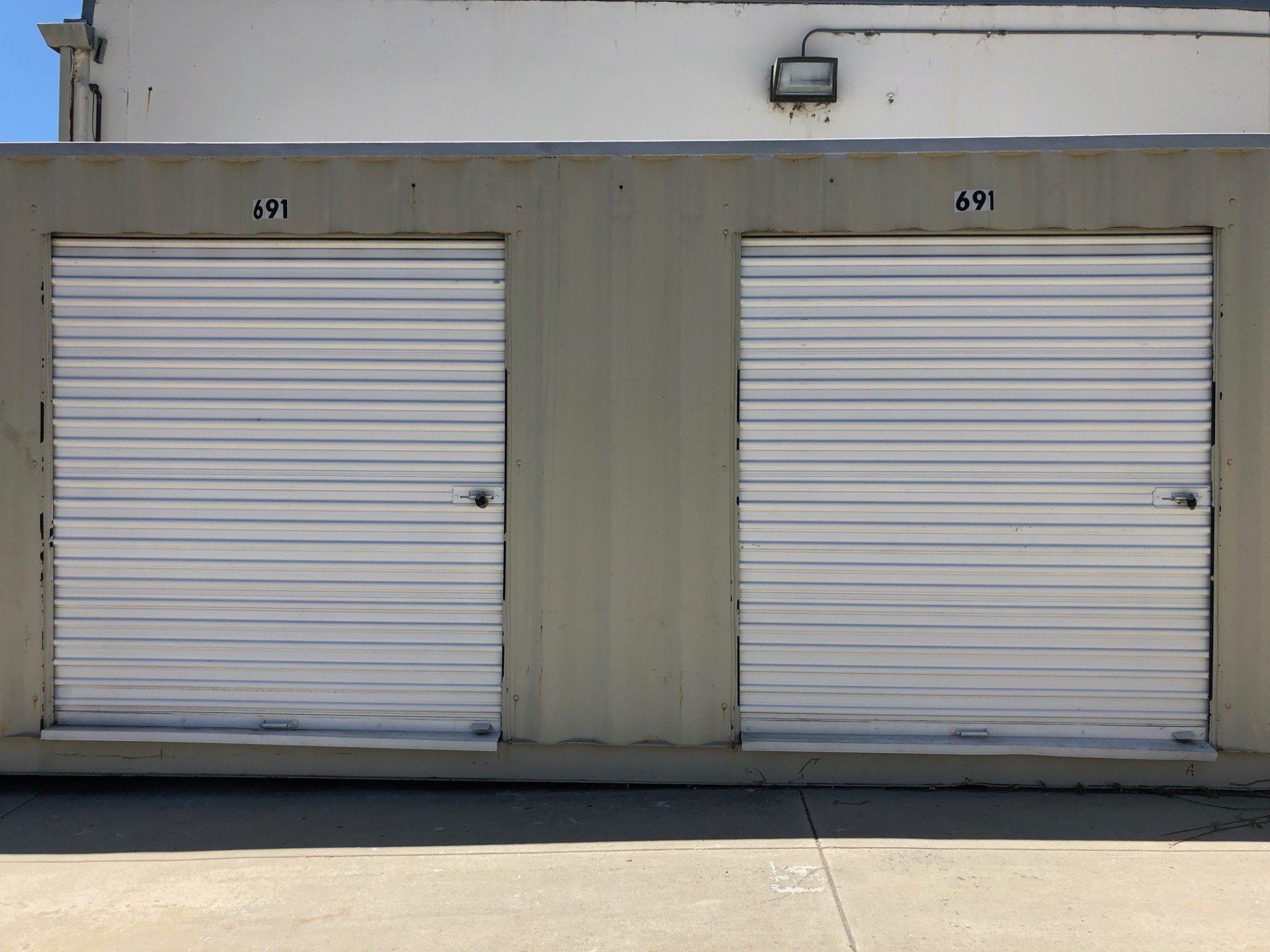 Orange Storage Units — Self-storage in Santa Cruz, CA Two white storage unit doors numbered 69 and 67.