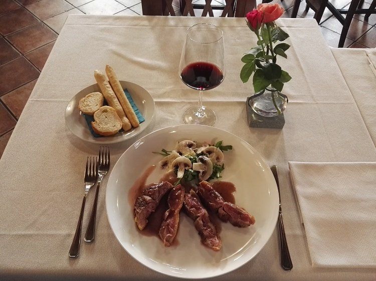 tavola apparecchiata con piatto di carne e funghi