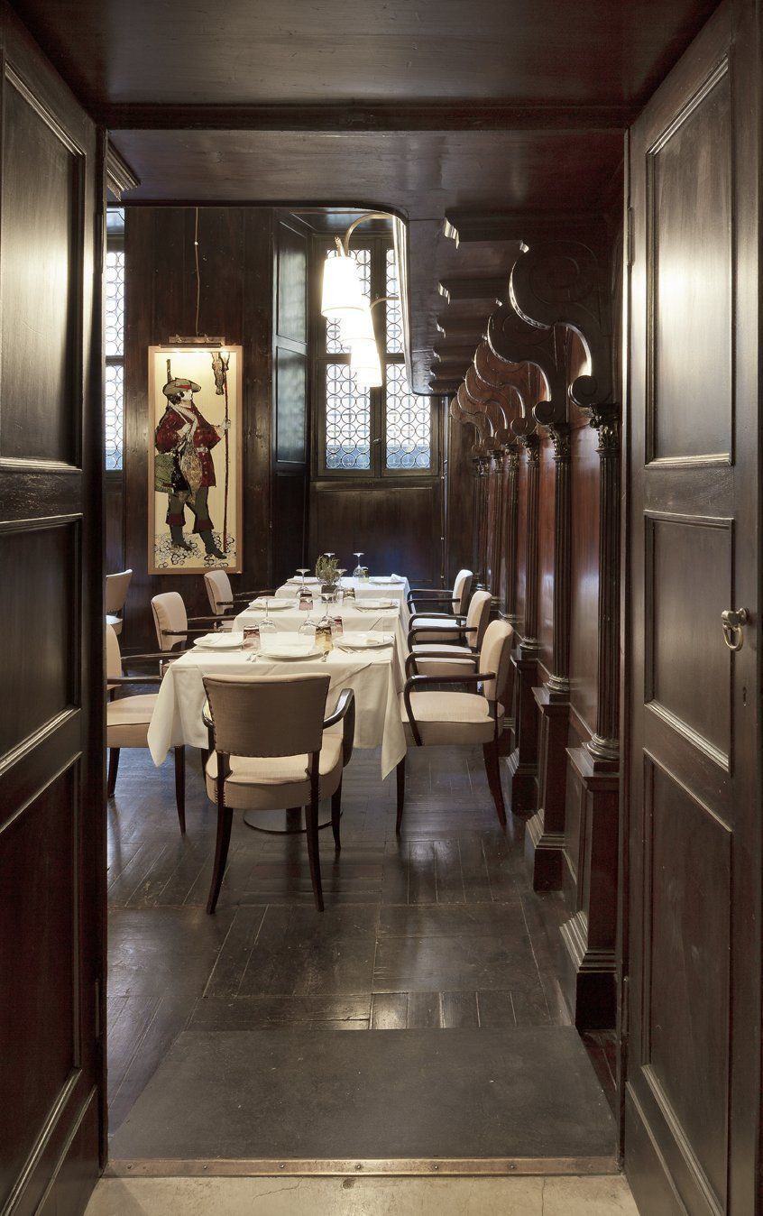 Una sala da pranzo con tavoli e sedie e un quadro alla parete