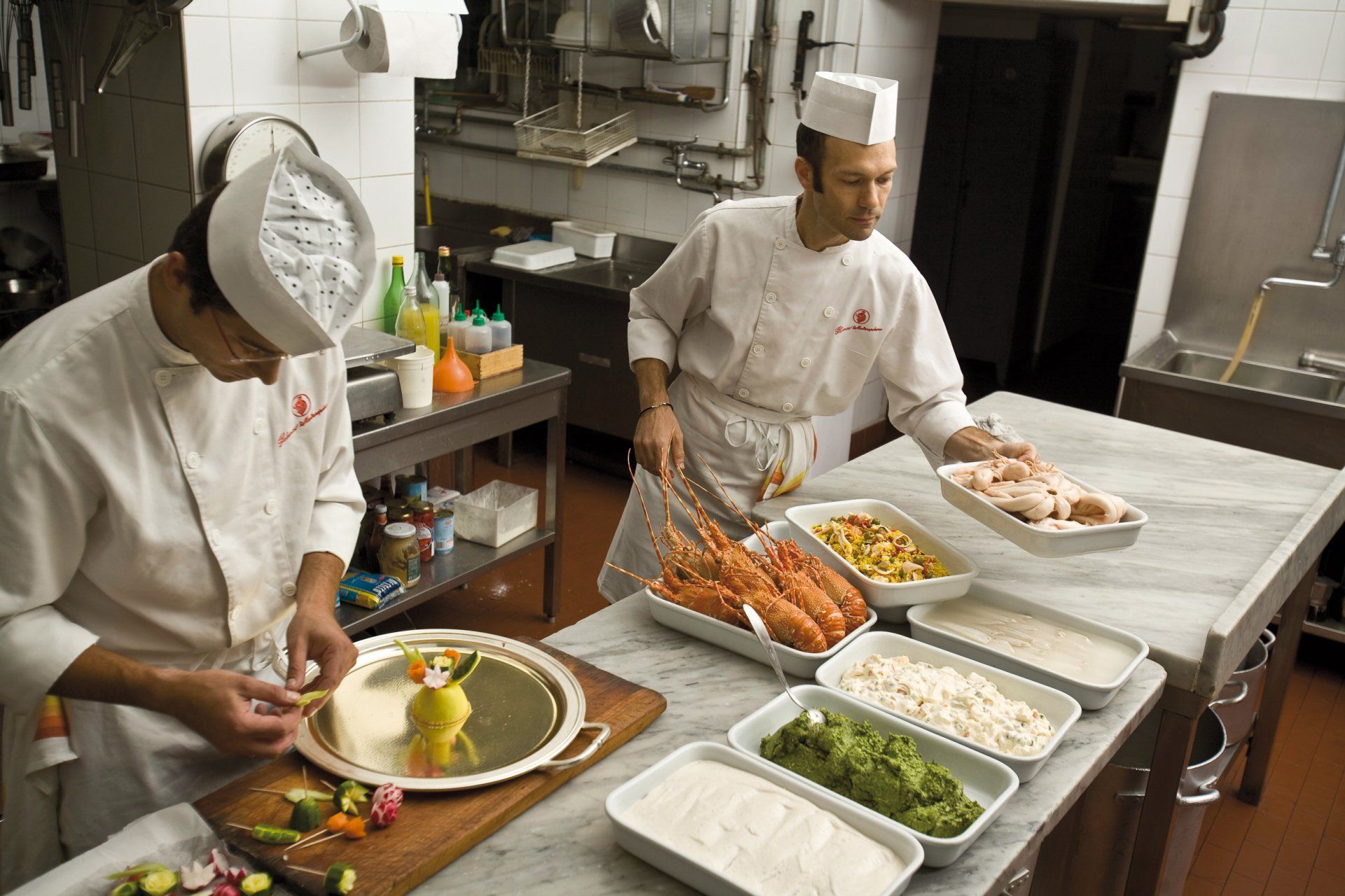 Due chef stanno preparando il cibo nella cucina di un ristorante