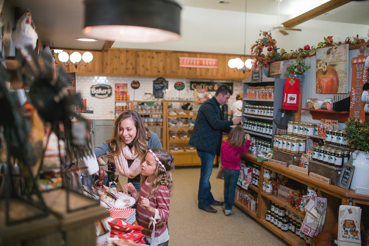 A man and two children are shopping in a store with a sign on the wall that says