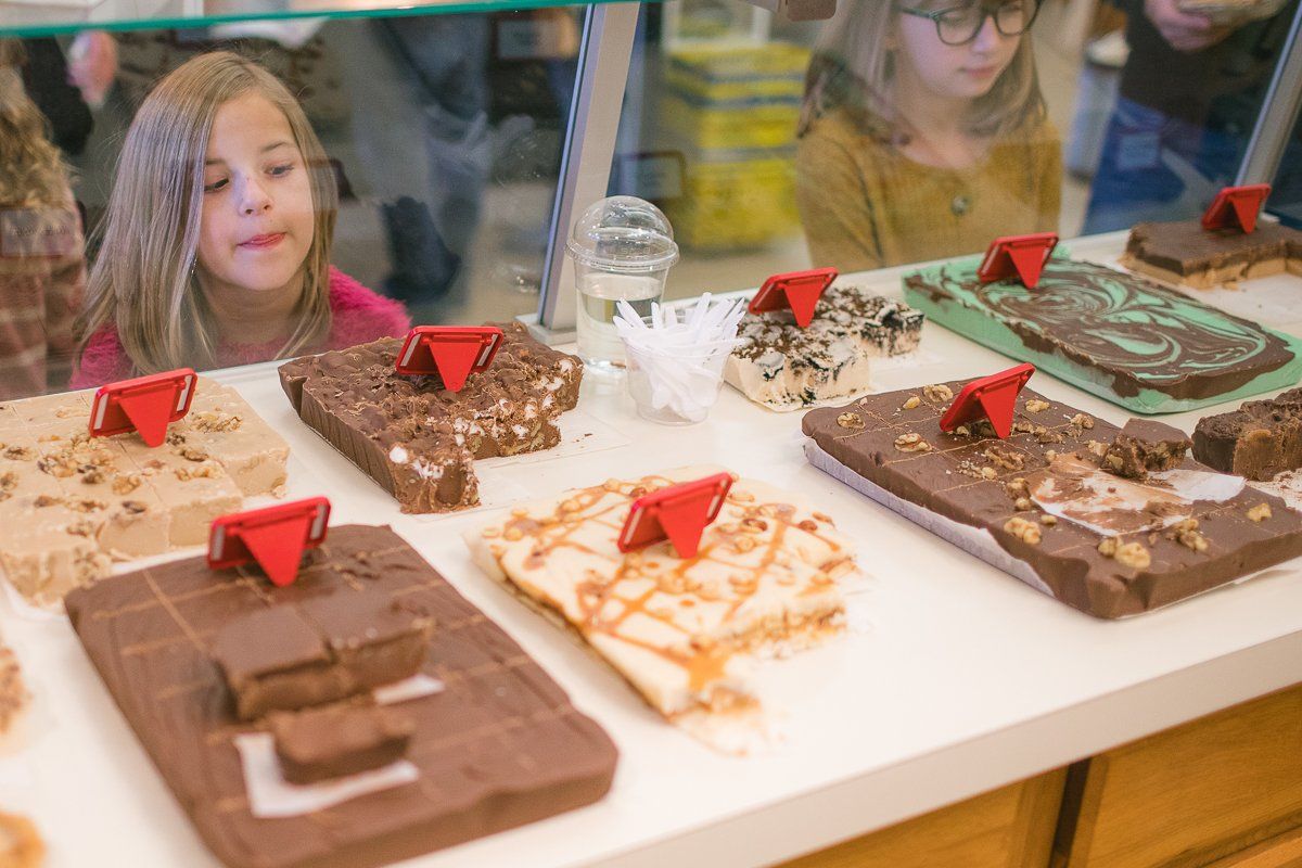 A girl is looking at a display of chocolate fudge