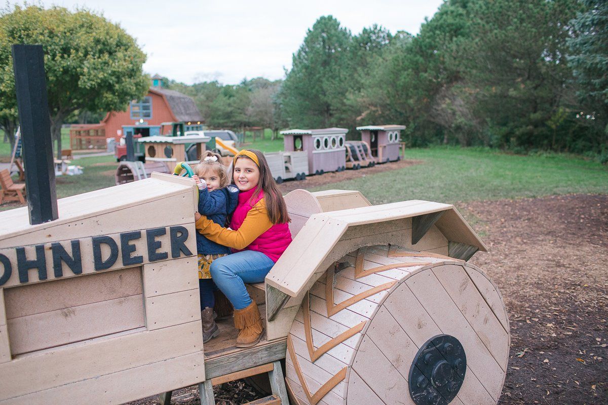 A woman and child sit on a john deer tractor