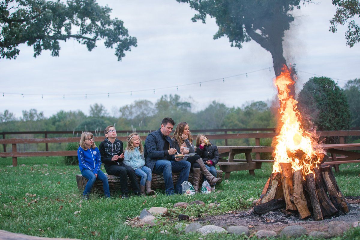 A group of people are sitting around a fire pit