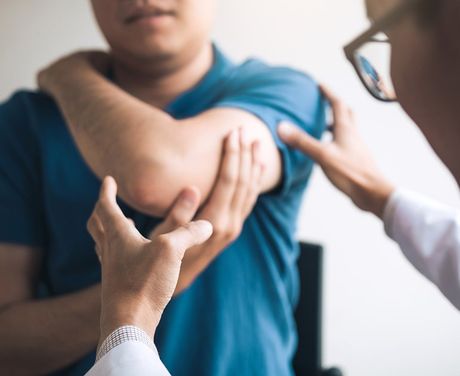 Doctor Checking Patients Elbows — Opelika, AL — Meals Chiropractic Clinic Doctor Checking Patients Elbows — Opelika, AL — Meals Chiropractic Clinic