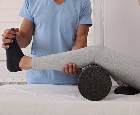 Therapist Treating Knee Of A Female Patient — Opelika, AL — Meals Chiropractic Clinic Therapist Treating Knee Of A Female Patient — Opelika, AL — Meals Chiropractic Clinic