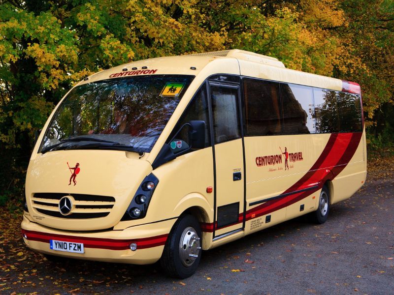 A mercedes bus is parked on the side of the road