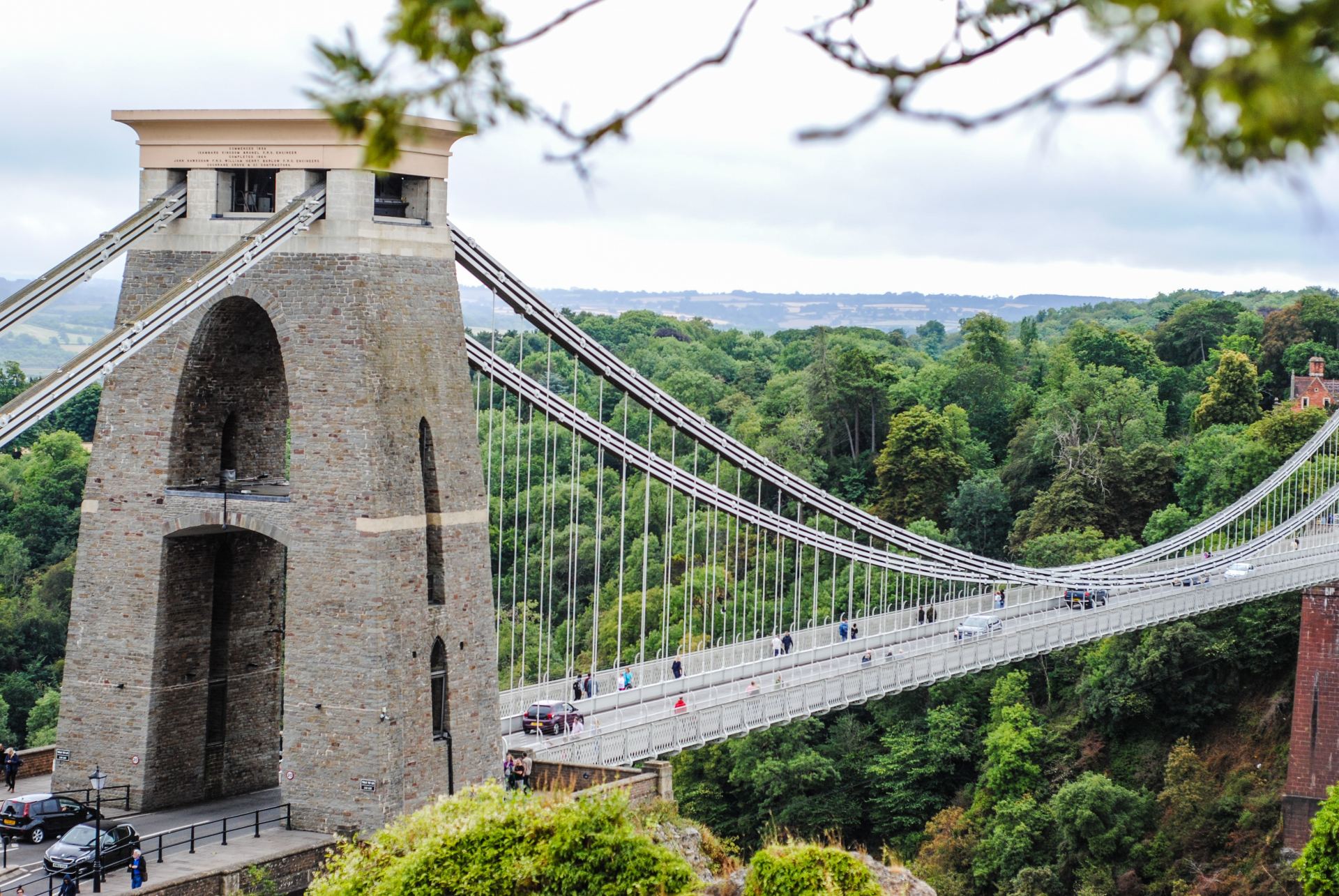 A bridge with a tower on top of it is surrounded by trees.