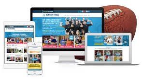 Website displayed on various devices; tablet, phone, desktop, laptop; football beside the computer.