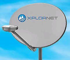 Xplornet satellite dish, light gray, mounted on a pole, against a bright blue sky.