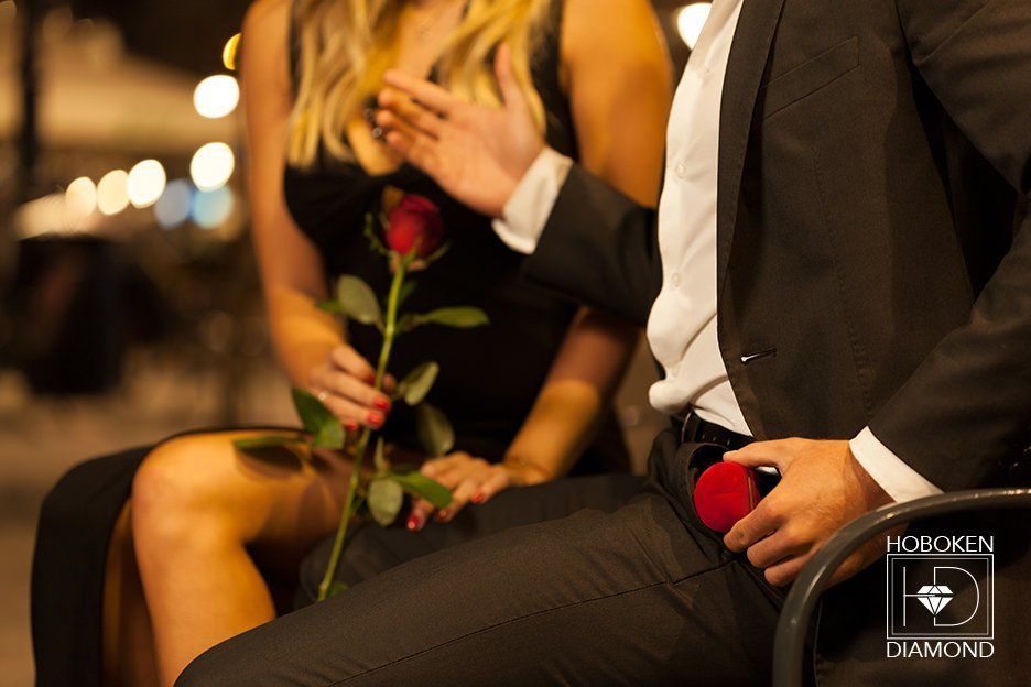 A man and a woman are sitting next to each other holding a rose.