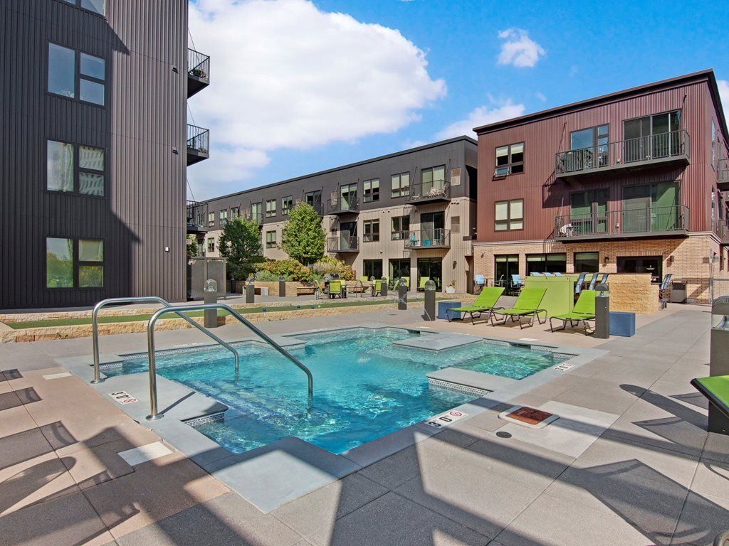 There is a large swimming pool in the middle of a building at 222 Hennepin Apartments.