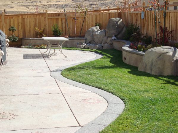 A patio with a table and chairs and a wooden fence