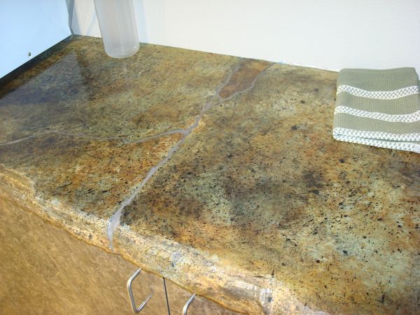 A kitchen counter with a towel and a bottle on it.