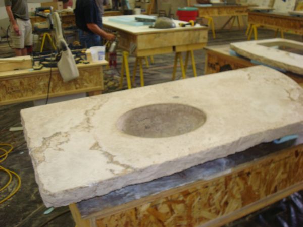 A large stone slab with a hole in the middle of it