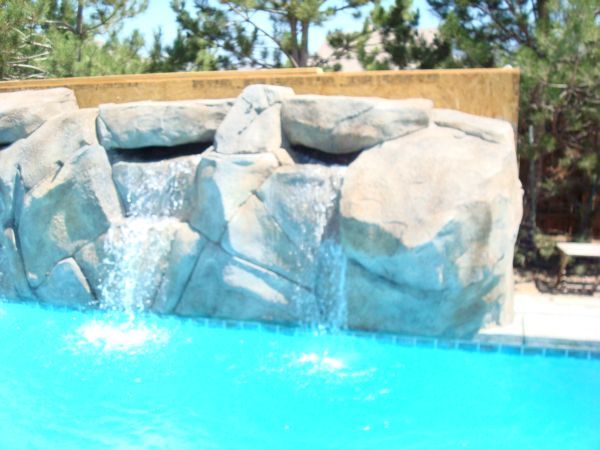 A waterfall in the middle of a swimming pool