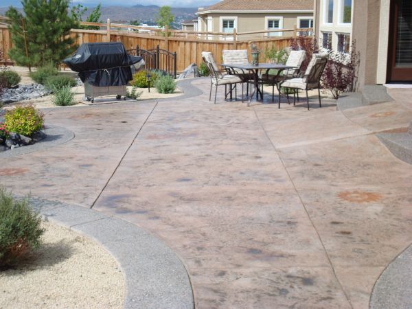 A patio with a table and chairs and a grill