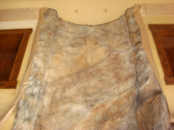A piece of cloth is hanging on a wall in a room