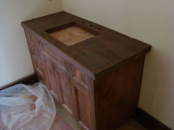 A wooden cabinet with a sink on top of it