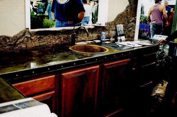 A kitchen counter with a sink and a mirror