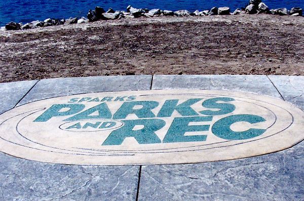 A sign on a sidewalk that says parks and rec
