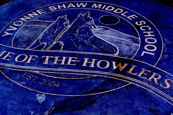 The logo for yvonne shaw middle school is on a blue cloth