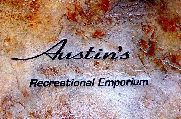 The logo for austin 's recreational emporium is on a rock
