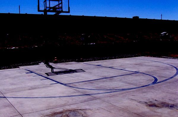 An empty basketball court with a basketball hoop in the background