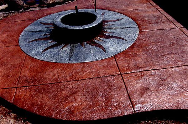 A fire pit in the middle of a concrete patio