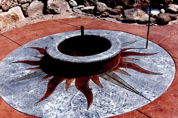 A fire pit with a sun design on it