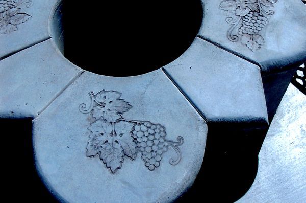 A piece of concrete with a drawing of grapes and leaves on it