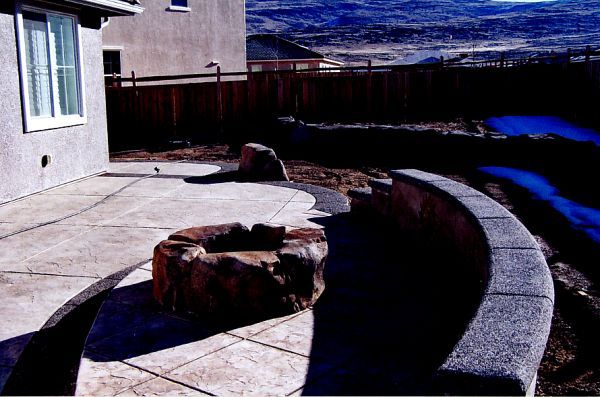 A patio with a fire pit in the middle of it