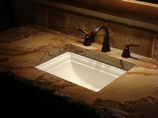 A bathroom sink with a faucet and a mirror